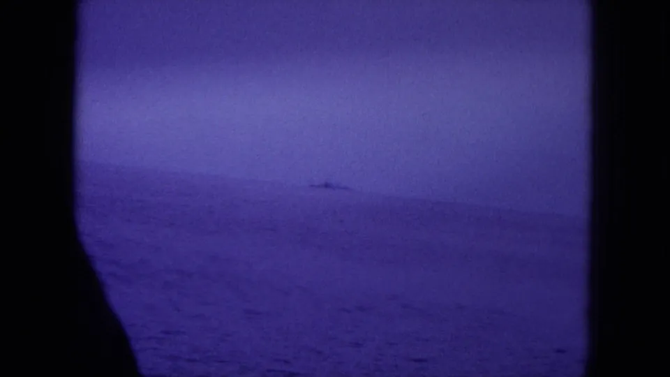 Distant naval vessel on the Hawaii horizon in a purple-toned 1964 8mm home-movie frame.
