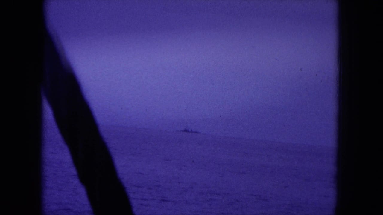 Open water seen through dark boat framing, with a small distant vessel near the horizon.