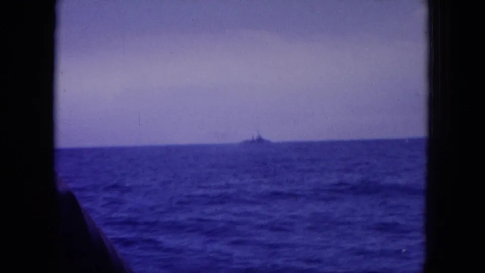 1964 Hawaii 8mm view across blue ocean toward a small distant ship silhouette on the horizon.