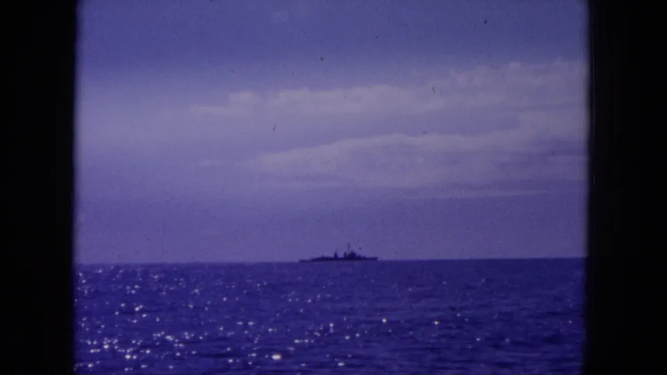 1964 Hawaii-area 8mm view of a distant ship low on the horizon, with sparkling ocean reflections and faded blue-purple color.