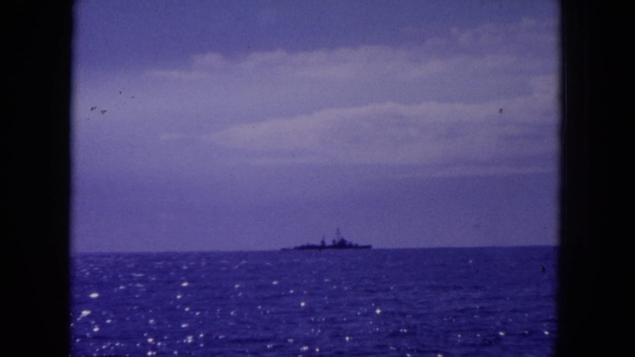 Distant ship silhouette on the horizon across a purple-blue sea.