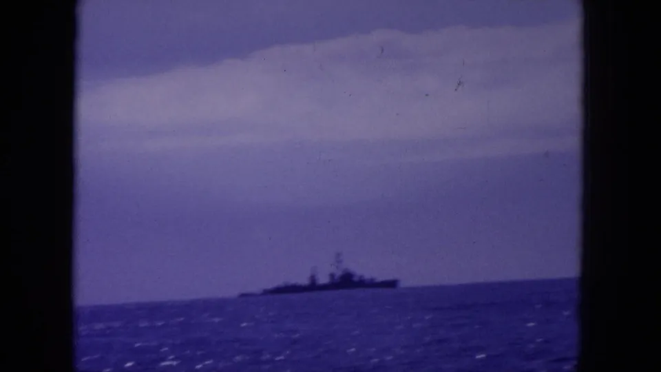 8mm 1964 Hawaii frame showing a distant ship-like silhouette near the horizon, softened by grain and color shift.