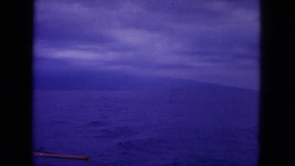1964 Hawaii 8mm frame looking over open sea toward a cloudy purple-blue horizon, with the vessel no longer distinct.