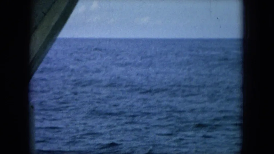 1964 8mm frame from Oahi, Hawaii, showing open ocean and horizon from a boat, with no dolphins clearly visible.
