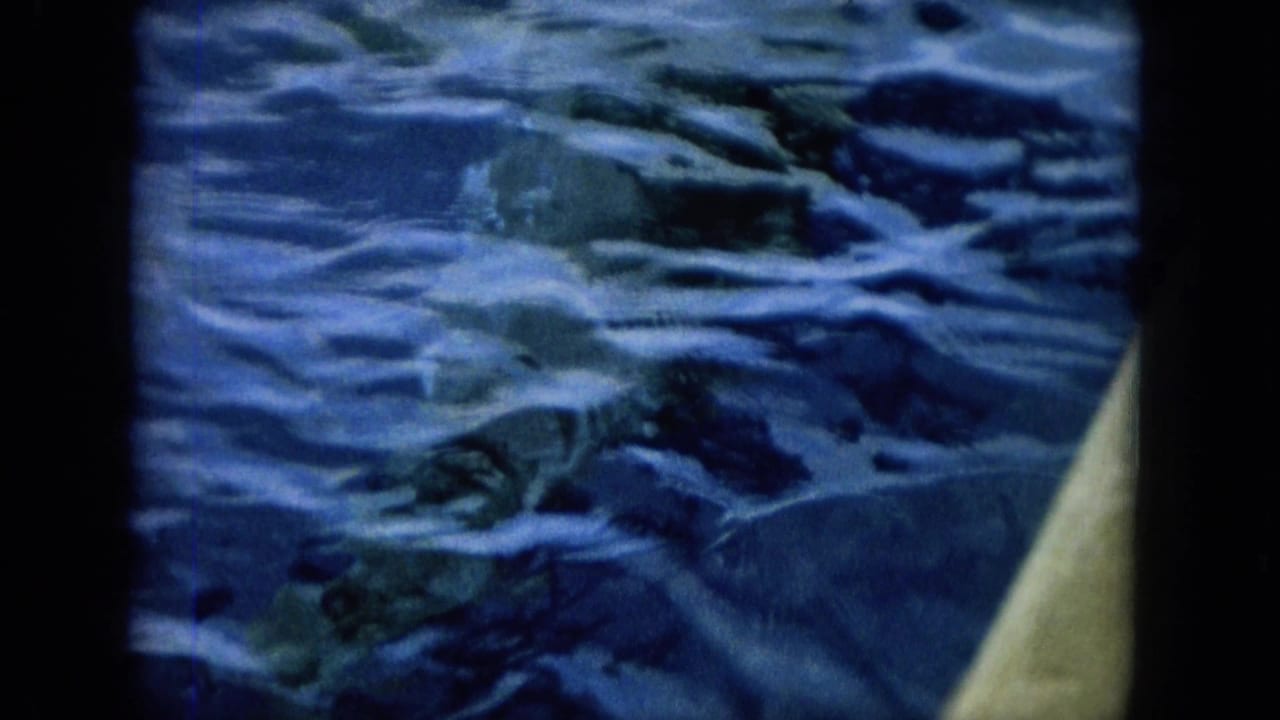 Shipboard 8mm view of blue Hawaiian ocean water, with the vessel edge visible at right and ripples across the frame.