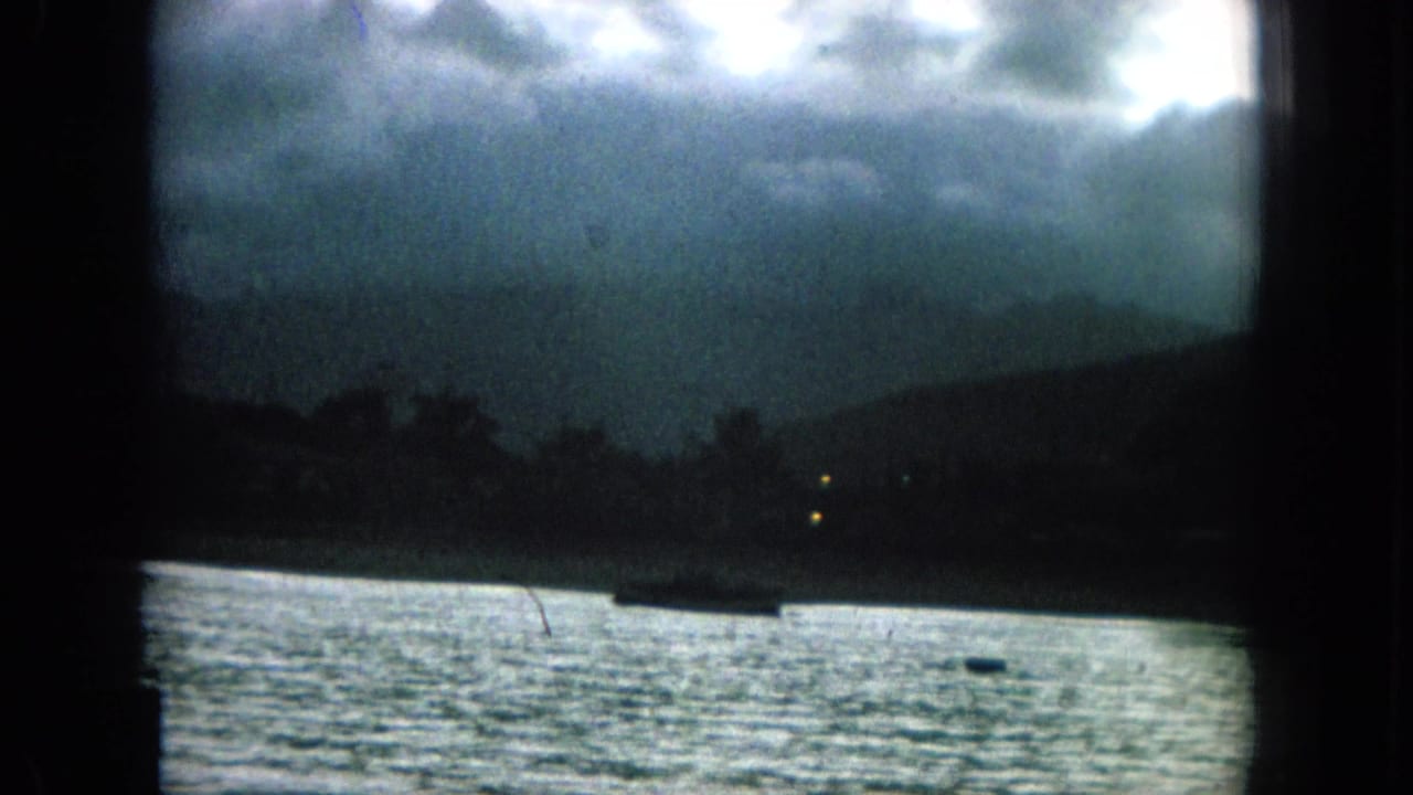 Stormy coastal water seen through dark film-frame borders.