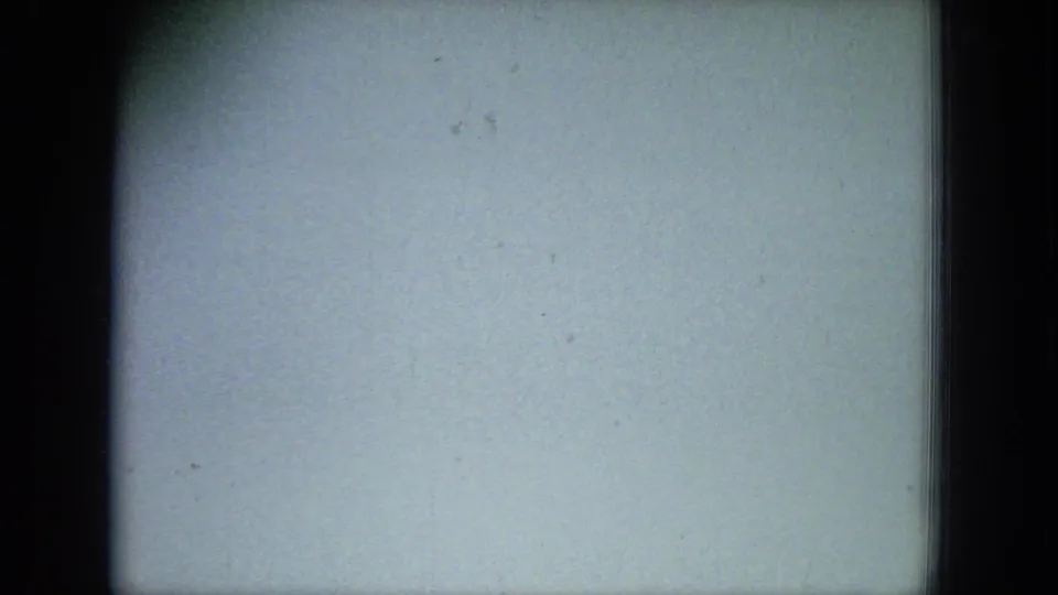 Pale, nearly blank 8mm frame with dark film borders, faint discoloration, and visible dust or scratches.