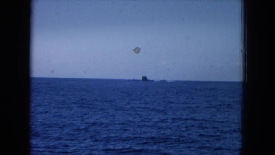 1964 Hawaii 8mm frame with a small unidentified object or vessel on the ocean horizon, seen through a window-like frame.