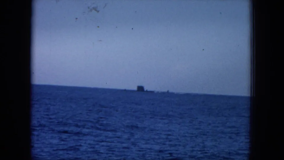 1964 Hawaii 8mm frame showing a tilted open-water view with a dark, distant object near the horizon and soft film texture.