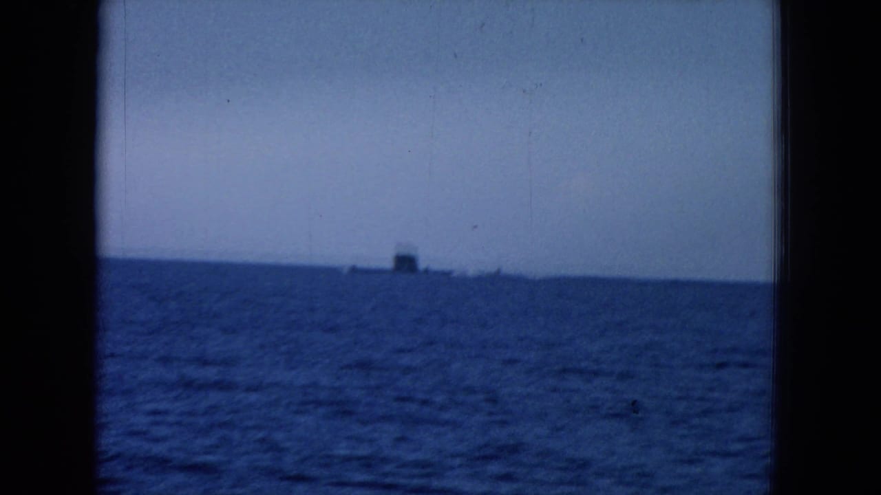 Open ocean and sky with a distant dark vessel on the horizon.
