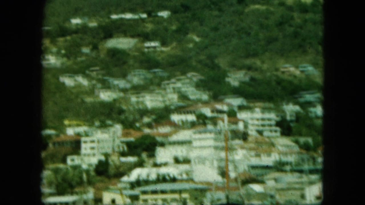 Soft distant view of hillside buildings above a waterfront area.