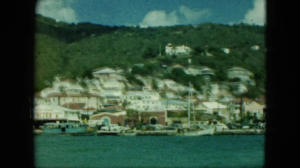 Soft 8mm view of a coastal town and marina below a green hillside, identified by metadata as Saint Thomas.