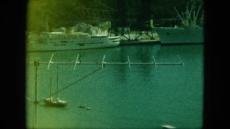 Cataloged Saint Thomas harbor frame showing a docked large ship, nearby pier, small sailboats, calm water, and dark vertical framing.