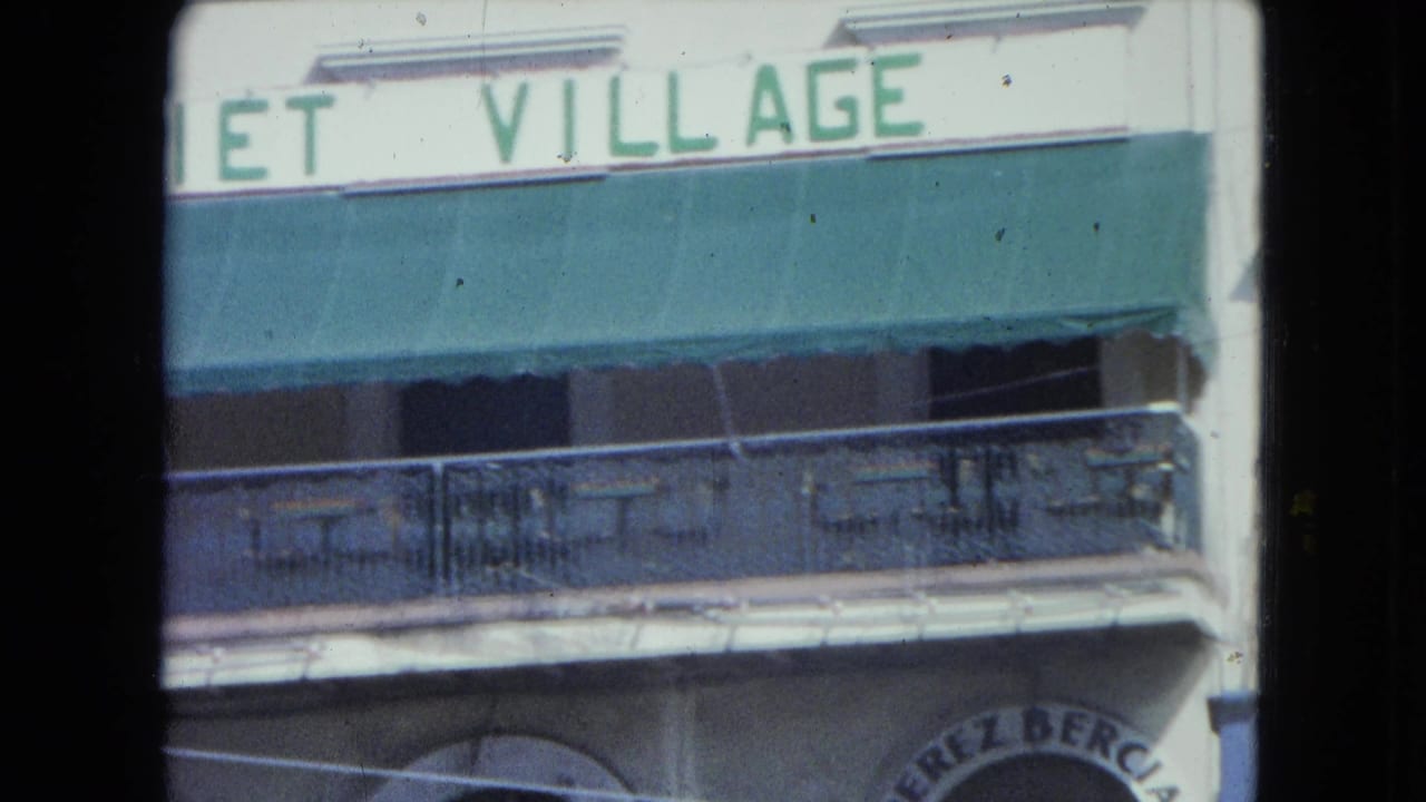 San Juan exterior with a partial Village sign above a green awning and balcony, with arched business lettering below.
