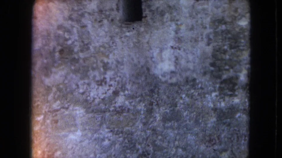Final 1964 San Juan frame focused on a worn masonry wall with a small dark opening and heavy 8mm texture.