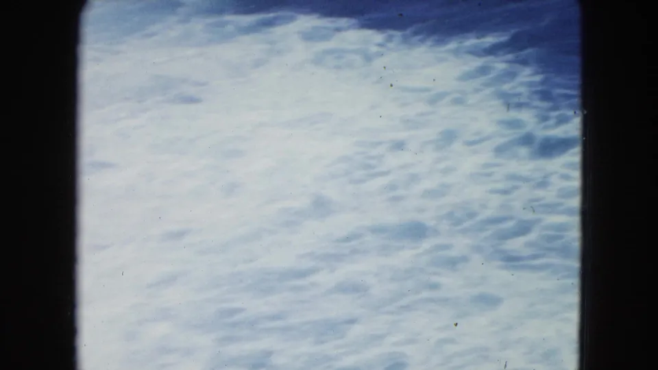 Pale foamy surf fills the final San Juan shoreline frame, with soft color and visible 8mm scan edges.