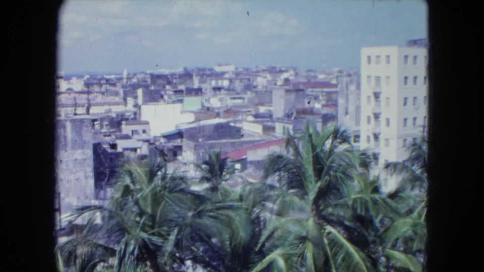 Elevated home-movie view of San Juan buildings, palms, and distant rooftops in 1964.