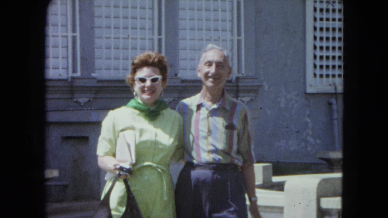 A smiling adult couple in 1960s clothing faces the camera while standing outside in San Juan, Puerto Rico.