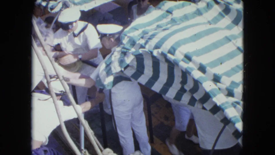 A boat scene shows uniformed sailors near railings and striped awnings, likely connected to the Navy return noted in the clip metadata.