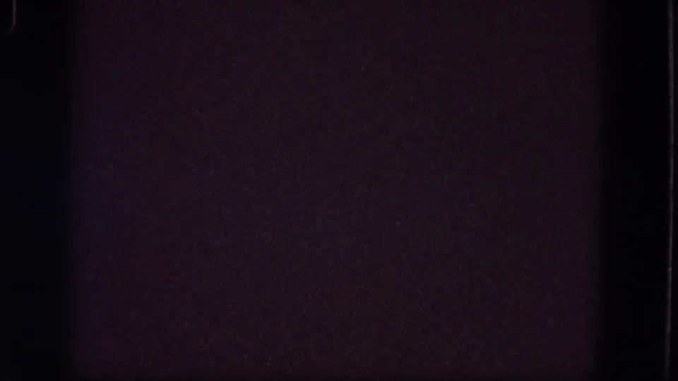 Obscured 1964 Troy 8mm home-movie frame with dark exposure, purple grain, faint specks, and contact-sheet boundaries.