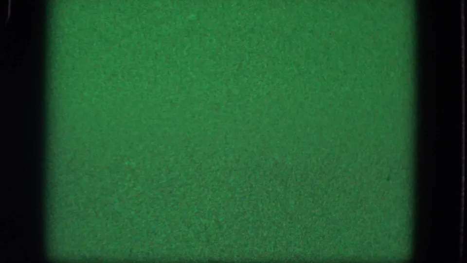 Green-tinted blank 8mm frame from the 1964 Troy metadata, showing grain, dark frame edges, and uneven exposure.