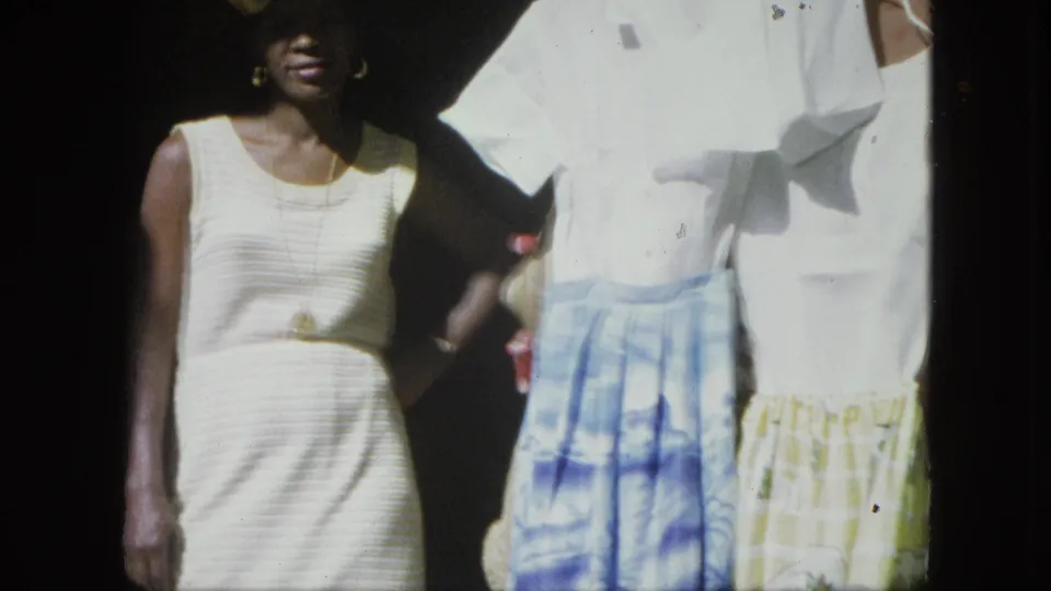A closer 8mm frame shows the woman partly cropped beside the same blue and yellow skirt display.