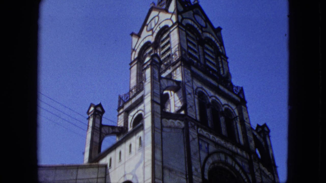 Church tower and upper facade against a bright blue sky.