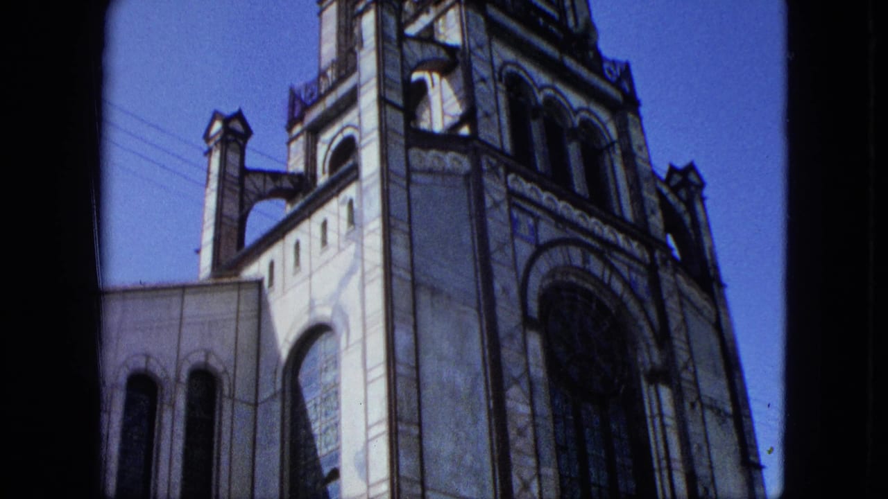 1964 U.S. Virgin Islands 8mm frame showing a stone church facade with tower details, arched windows, and part of a rose window.