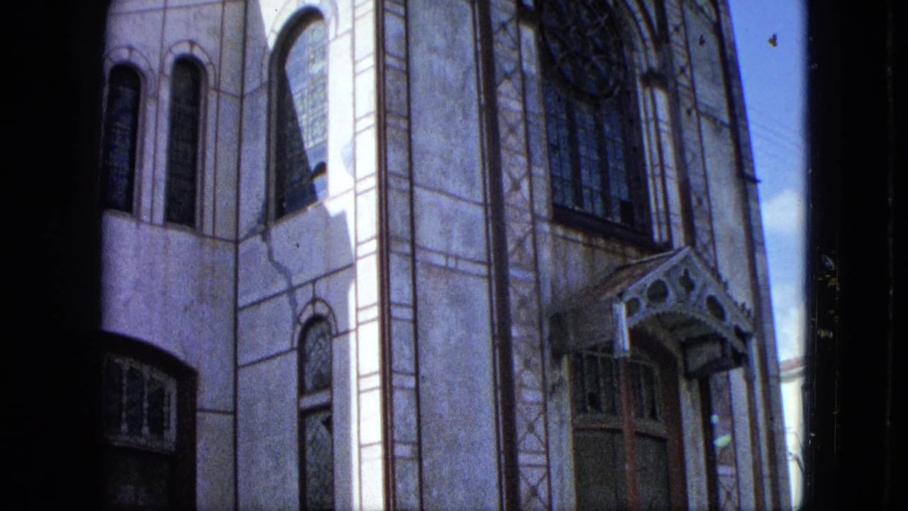 Close exterior view of a large church facade with arched windows and decorative entrance trim.