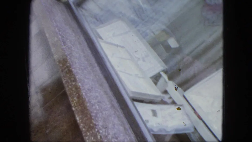 Angled U.S. Virgin Islands home-movie frame showing close architectural detail around the church entrance and adjacent wall.