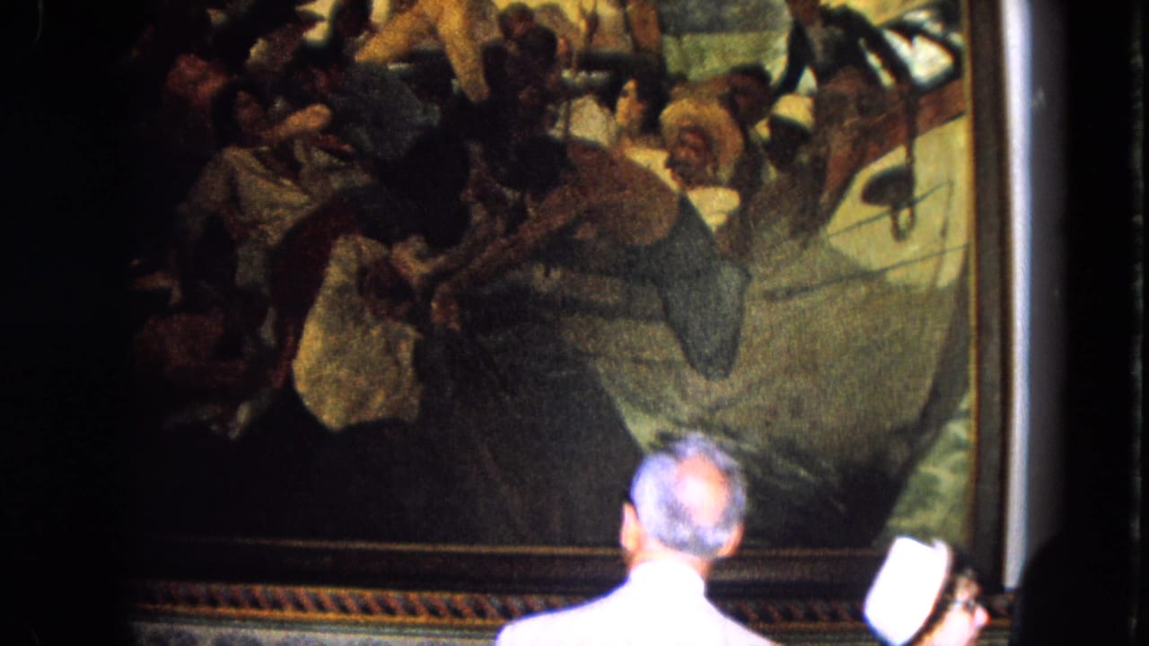1964 Venezuela travel footage shows a visitor seen from behind viewing a large framed historical painting in an indoor setting.