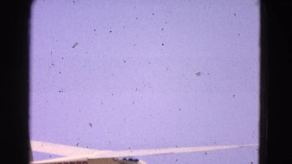 A cropped view of the glider wing and fuselage under a pale sky in 1964 Washington, DC area home-movie footage.