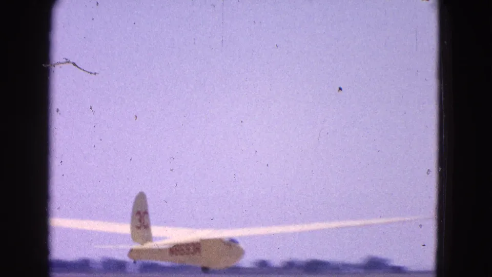 Rear view of the glider at an airfield, with tail number 30 and registration lettering visible in 1964 home-movie footage.