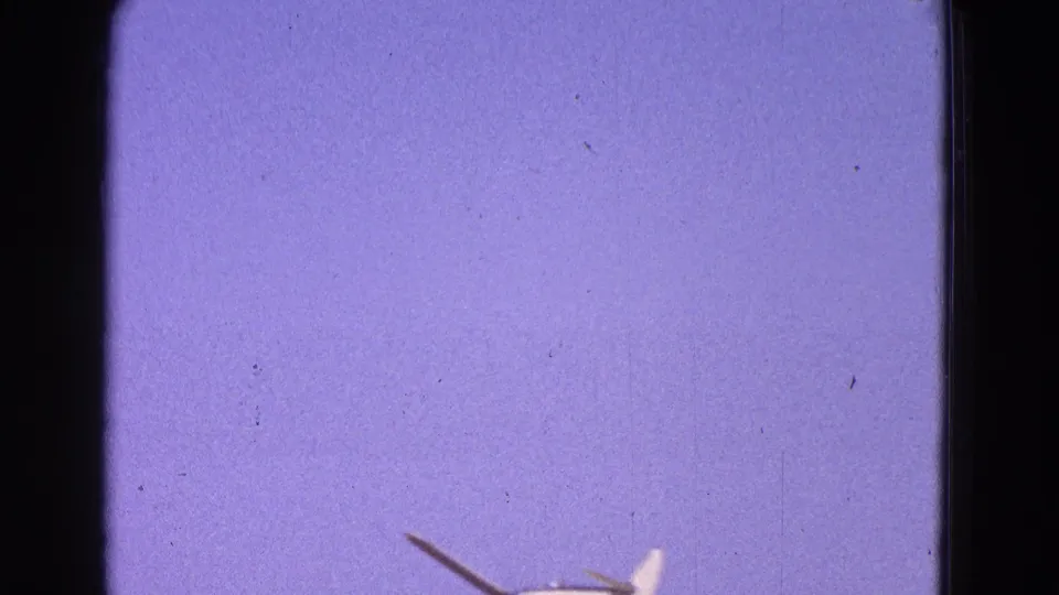 1964 Washington DC 8mm frame with a small white airplane partly visible near the lower edge against a purple-blue sky.