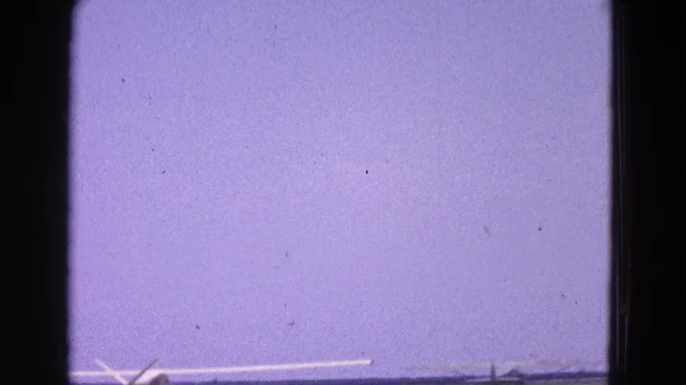 1964 Washington, DC home-movie frame showing a small aircraft beginning to lift off from the runway.