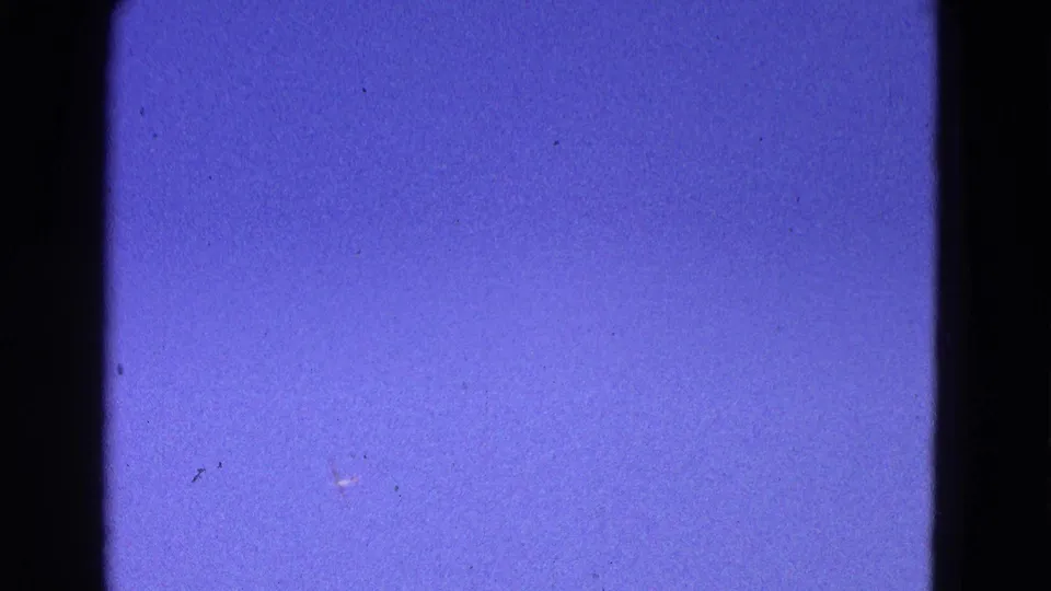Final frame shows blue sky in the 1964 Washington DC airfield clip, with 8mm grain, dust marks, and black frame edges.
