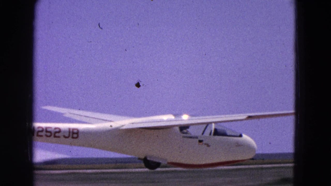 1964 8mm frame showing a white glider marked N252JB on a Washington, DC area runway.