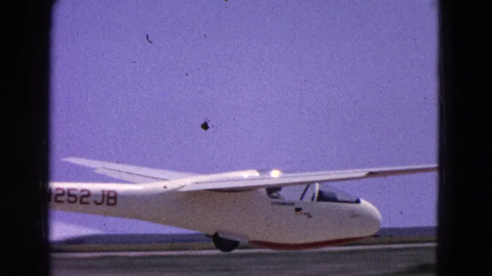 1964 8mm frame showing a white glider marked N252JB on a Washington, DC area runway.