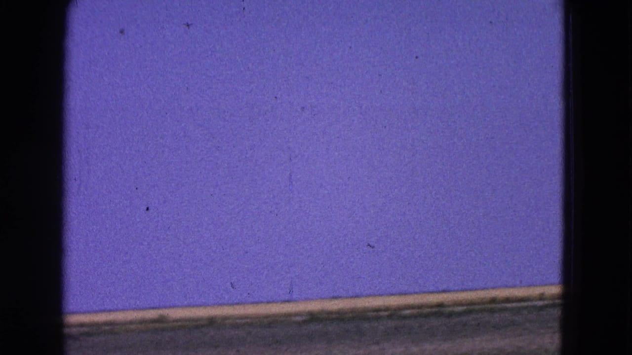 1964 Washington, DC 8mm frame showing a runway or flight-deck surface and open blue sky as the aircraft moves out of view.