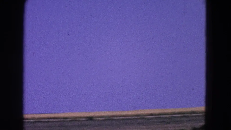 1964 Washington, DC 8mm frame dominated by clear sky, with the runway horizon low in frame and visible film-gate edges.