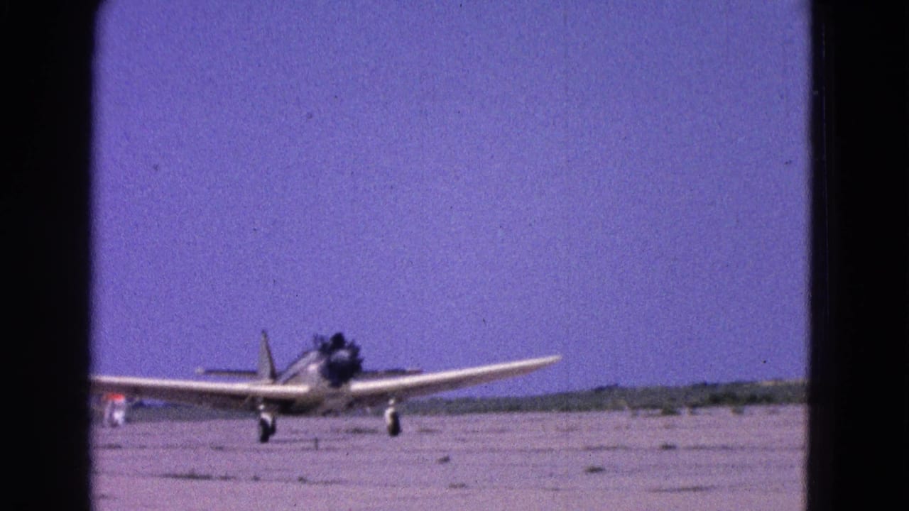 1964 8mm frame showing a small propeller aircraft on an airfield runway near Washington, DC.