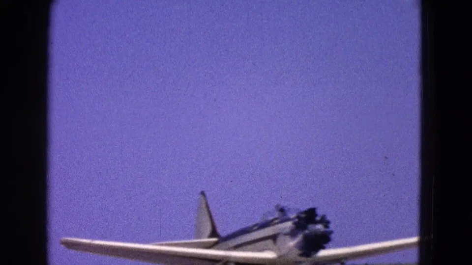 The small white aircraft remains low in frame as it moves along the runway in the 1964 Washington, DC home-movie footage.