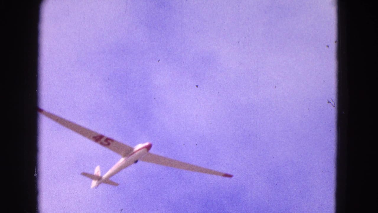 White glider seen from below with red number 45 on one wing.