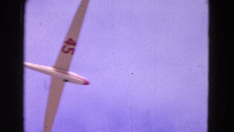 A 1964 8mm frame catches the glider partly cropped as it moves through the Washington, DC sky.