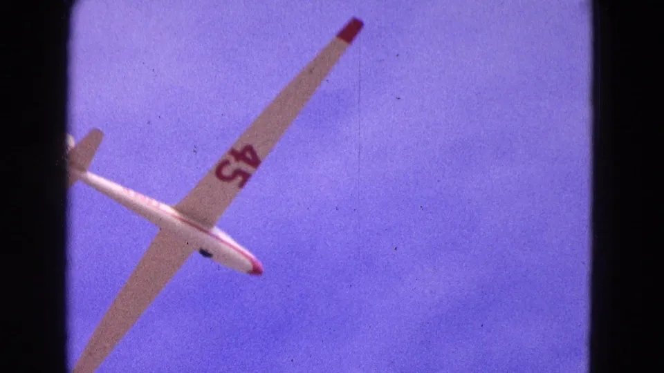 The glider turns across the final 1964 home-movie frame, with number 45 and red wing tips visible above Washington, DC.