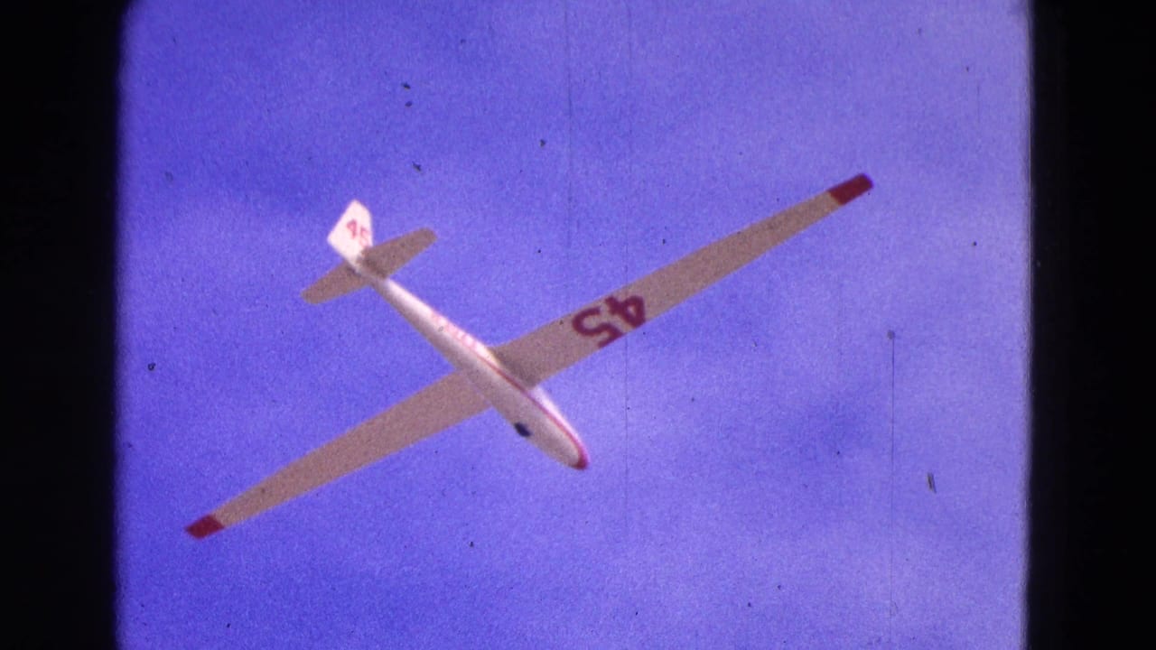 White glider marked 45 seen from below against blue sky.