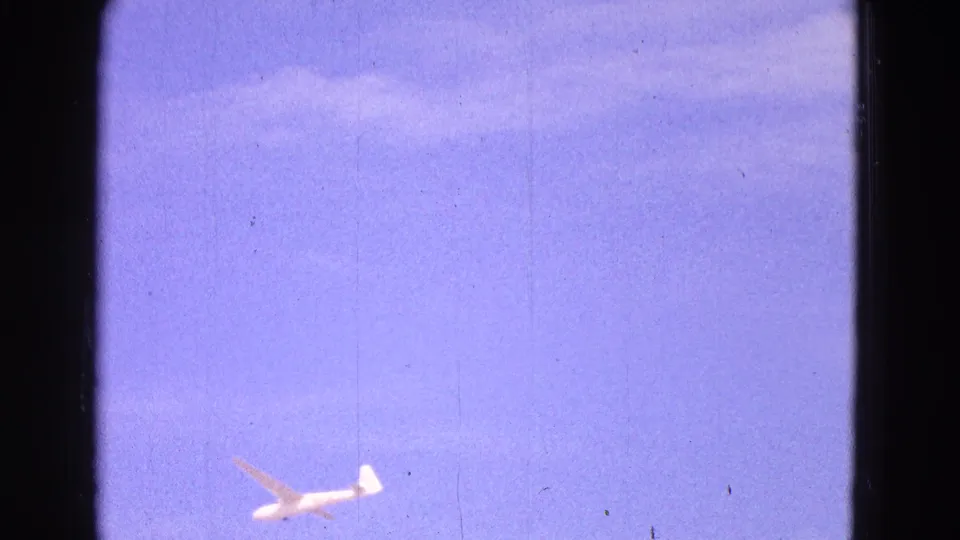 The distant glider remains visible against the open Washington, DC sky in this 1964 8mm home-movie frame.