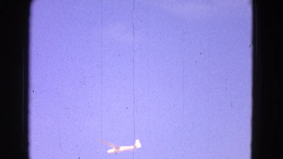 A small white glider appears low against a faded blue-purple sky in 1964 8mm home-movie footage from the Washington DC metadata context.