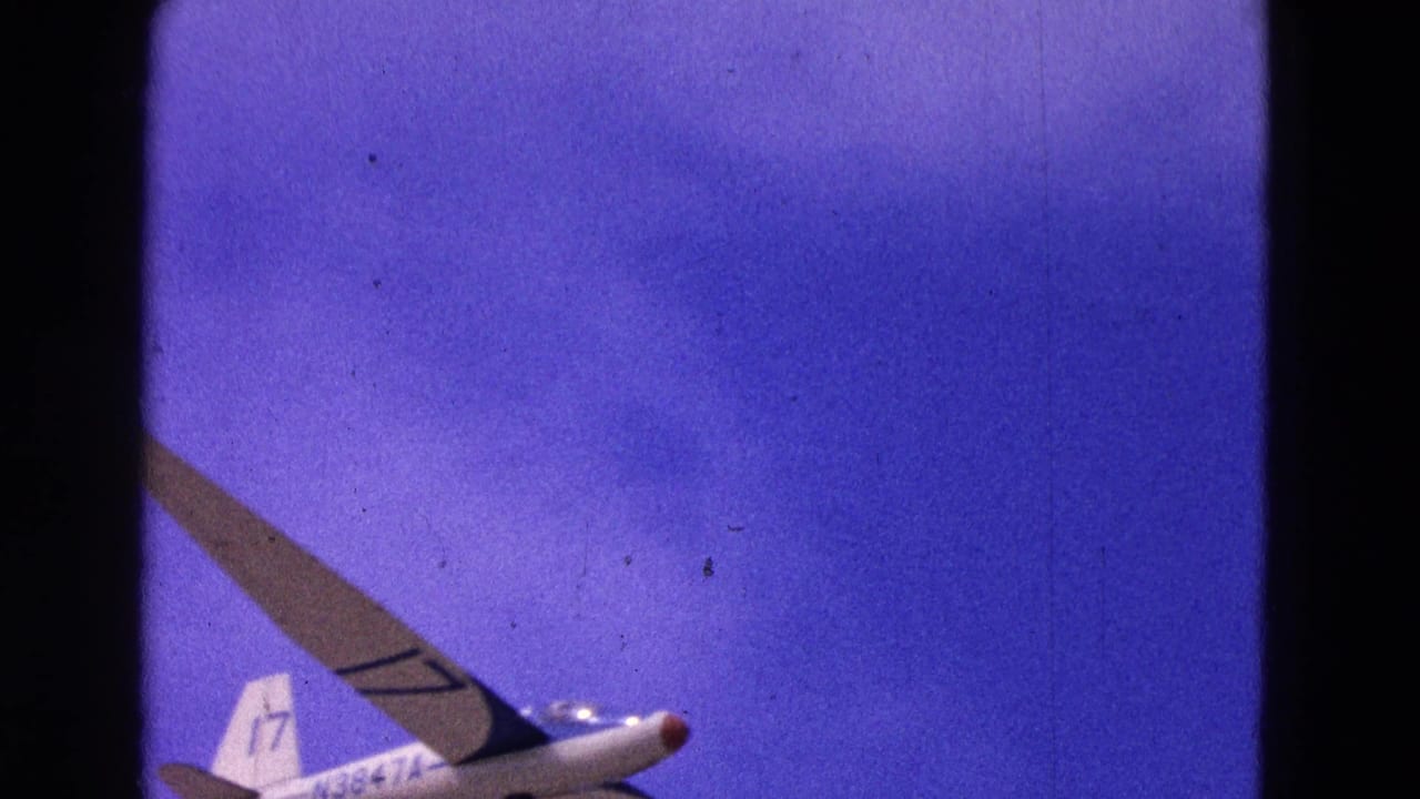 1964 8mm frame of a white glider with tail number 17 crossing a deep blue sky in the Washington, D.C. clip.