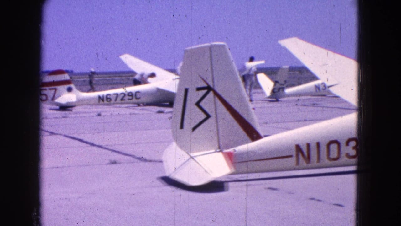 Small light aircraft parked on a tarmac with visible tail numbers and a close foreground tail.